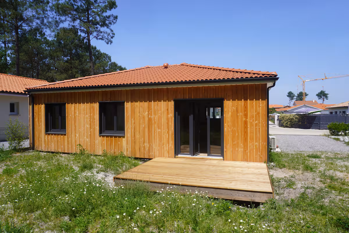 La maison en bois entourée de pins